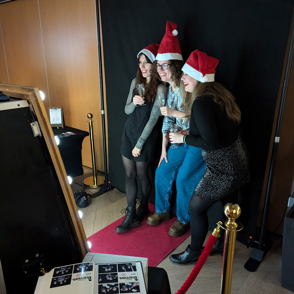 Friends posing with fun party props at photo booth